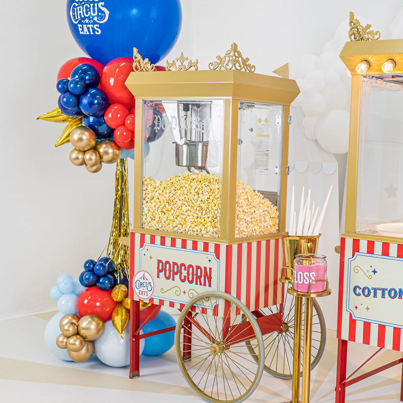 Luxe Popcorn Cart next to a balloon tower and Luxe Cotton Candy Cart