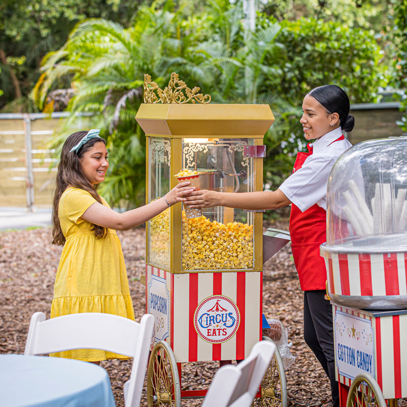 girl receiving popcorn from our uniformed attendant